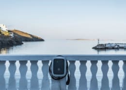 Ladegerät für Elektroautos an einer Mauer mit Blick aufs Meer