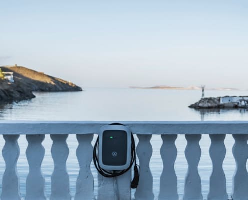 Ladegerät für Elektroautos an einer Mauer mit Blick aufs Meer