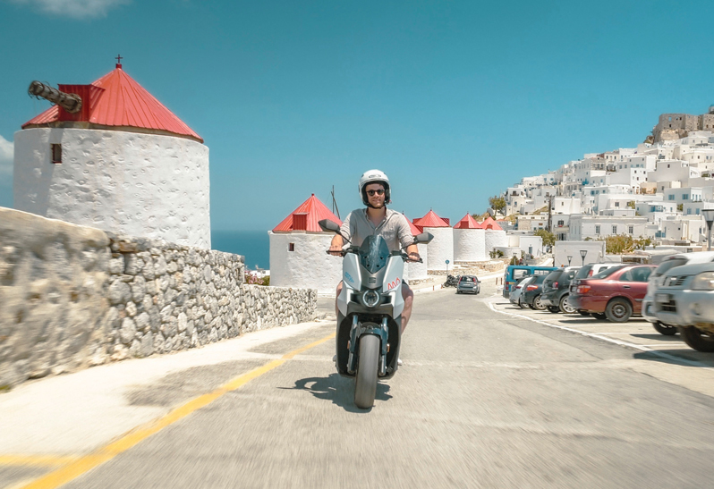 Mann mit Helm steht auf Moped