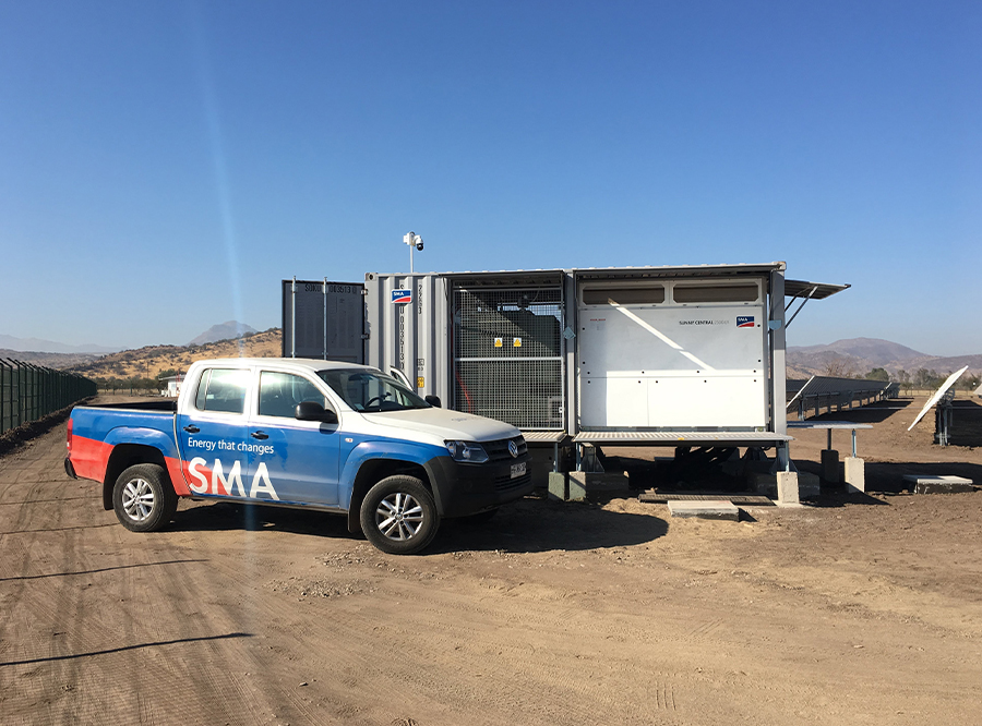 Ein Pick up-Truck steht vor einem Container in der Atacama-Wüste.
