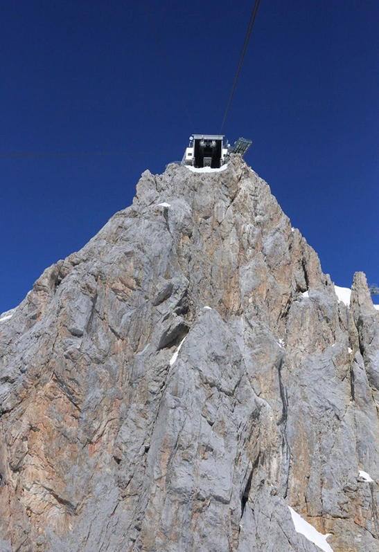 Blick von unten auf eine Huette auf dem Berg
